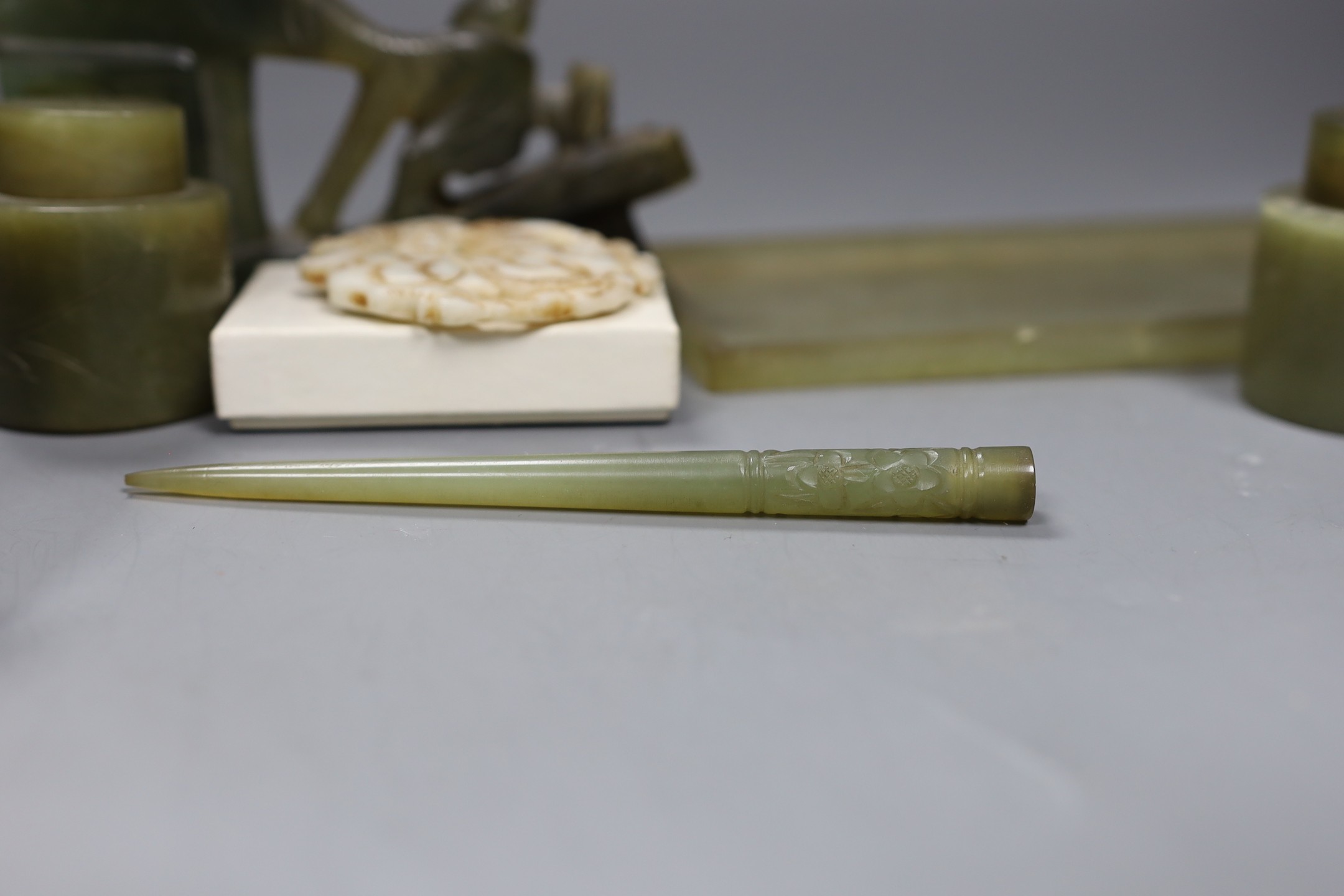 A Chinese bowenite jade desk set (7) and a plaque, model of junk 16cms high